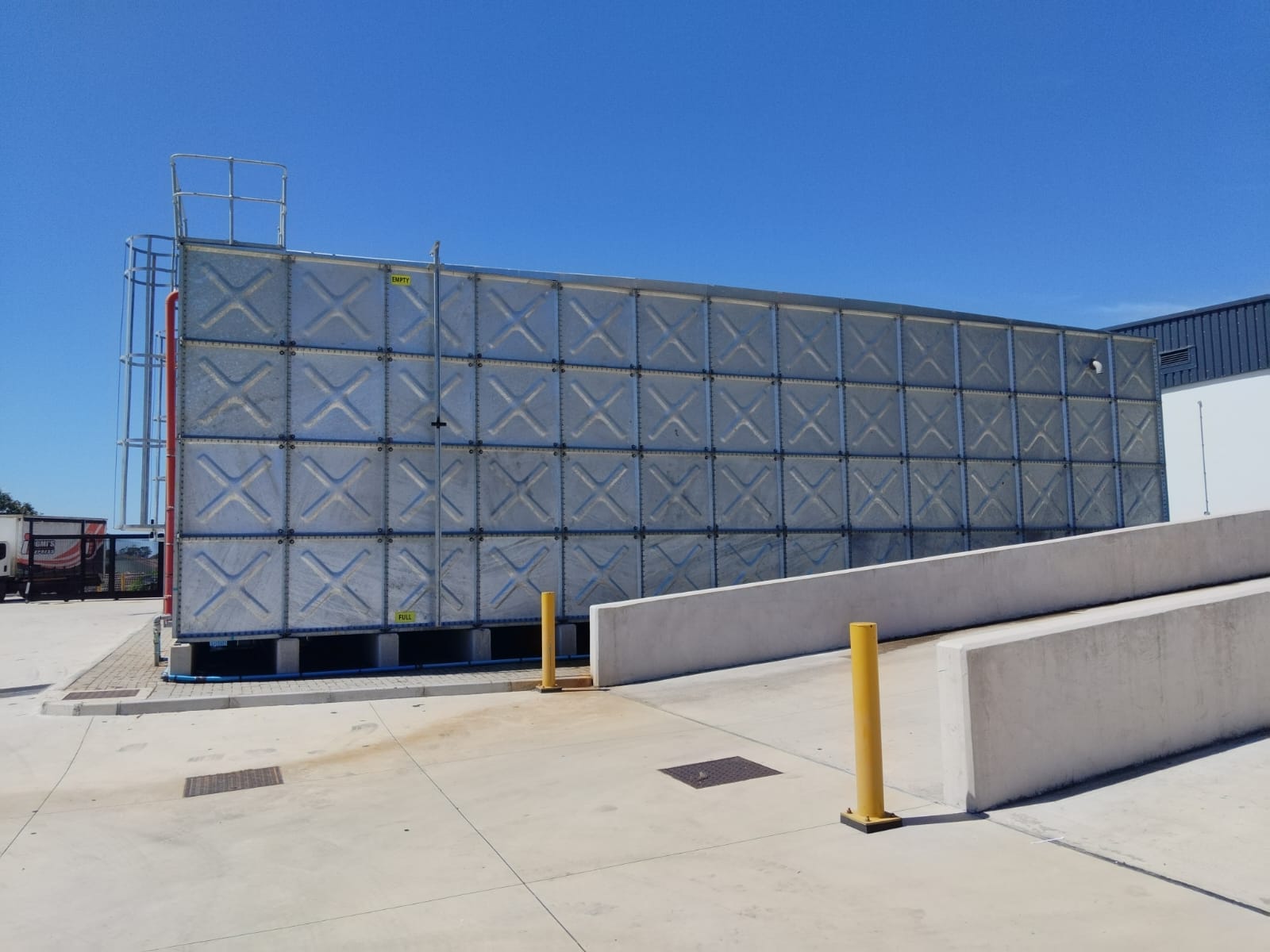 Side view of the Bidfood 1 ML steel tank on concrete plinths beside the loading ramp, Port Elizabeth