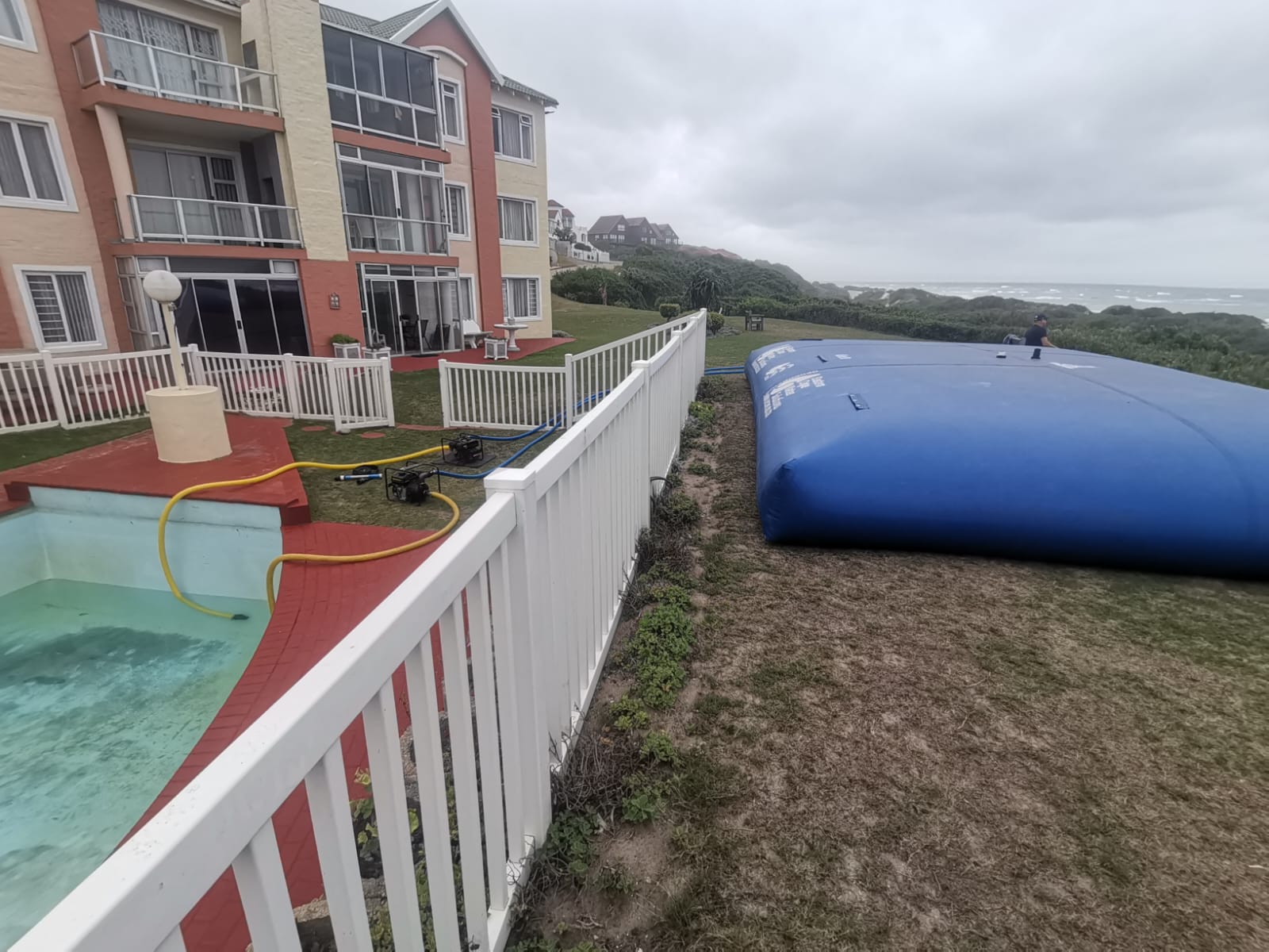 Filled water storage bladder next to a swimming pool at an Aston Bay complex