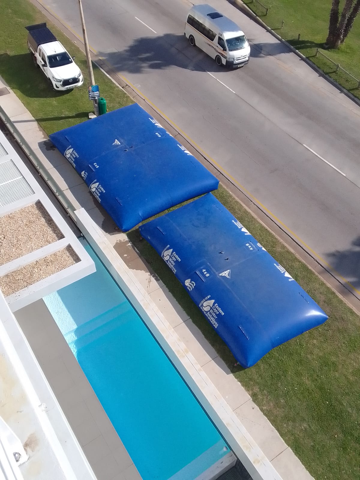 Aerial view of water bladders next to residential pool for water storage